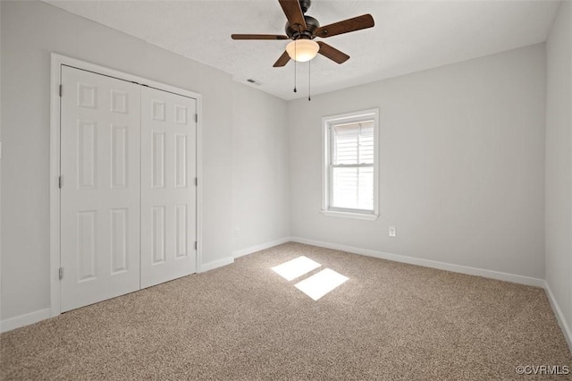 unfurnished bedroom featuring a closet, ceiling fan, and carpet