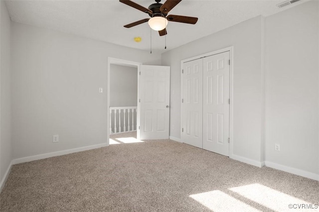 unfurnished bedroom featuring carpet flooring, visible vents, baseboards, and a closet