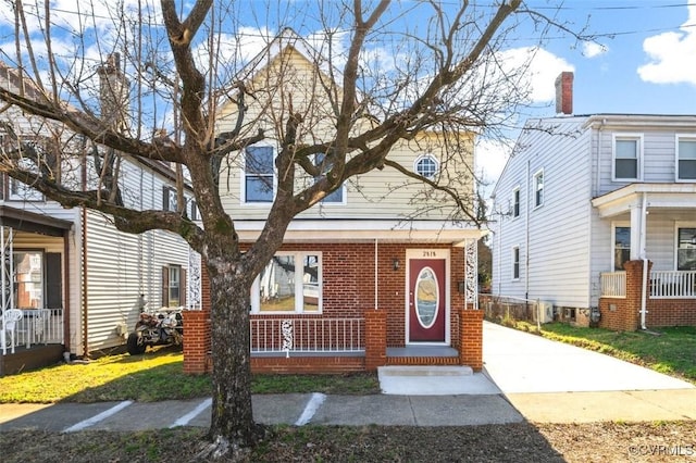 view of front of house with a porch and brick siding