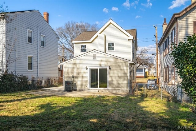 rear view of house with a patio, central AC, and a lawn