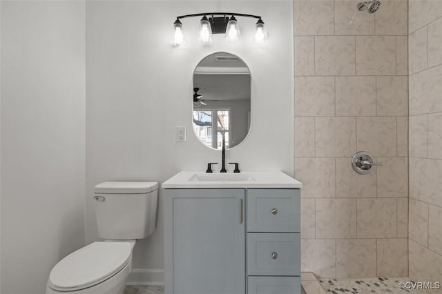 full bath with baseboards, toilet, tiled shower, vanity, and a ceiling fan