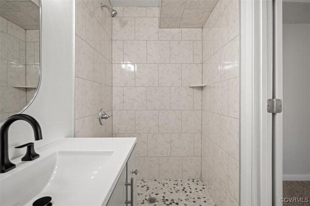 bathroom with vanity and tiled shower