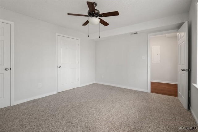 unfurnished bedroom featuring visible vents, baseboards, carpet, and a ceiling fan