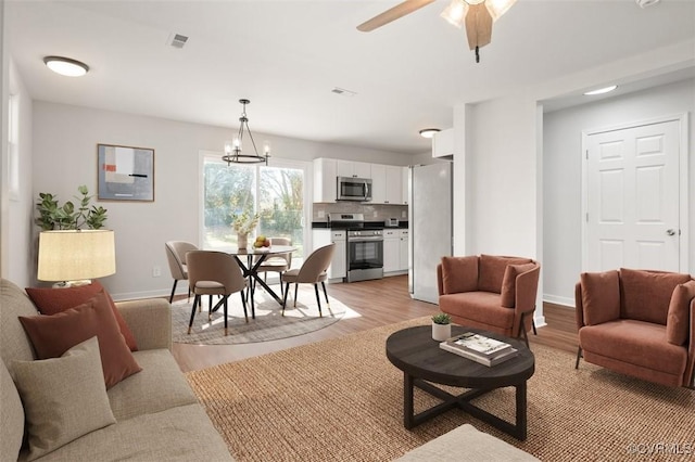 living room featuring visible vents, baseboards, and light wood-type flooring