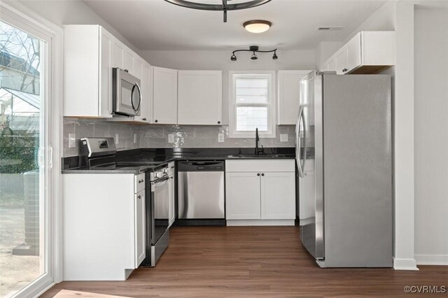 kitchen with sink, tasteful backsplash, dark hardwood / wood-style floors, stainless steel appliances, and white cabinets