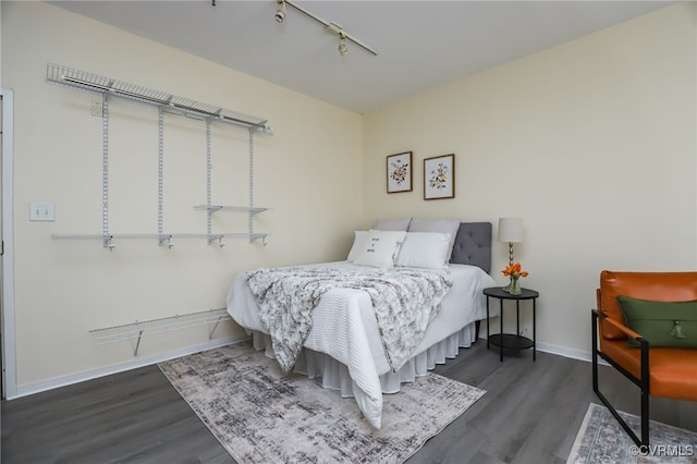 bedroom featuring dark hardwood / wood-style floors and rail lighting