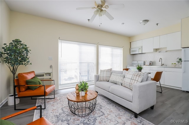 living room featuring sink, ceiling fan, and light hardwood / wood-style flooring