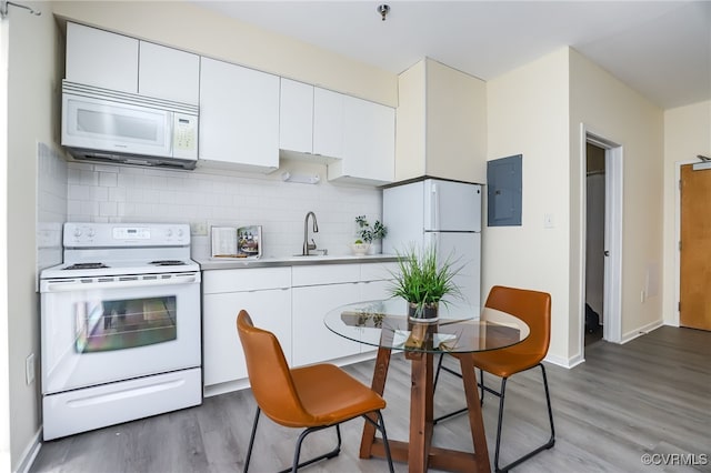 kitchen featuring decorative backsplash, white cabinets, white appliances, and electric panel