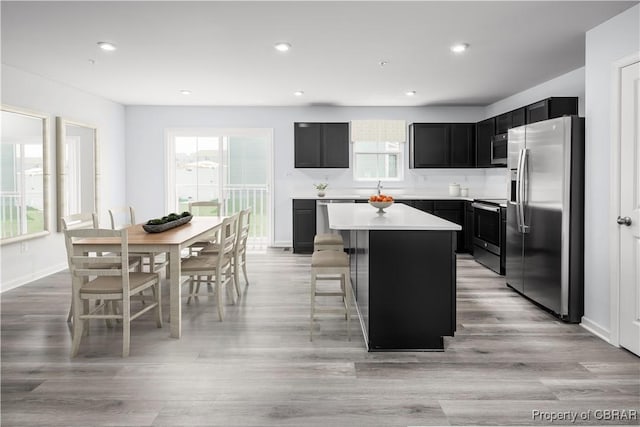 kitchen with plenty of natural light, stainless steel appliances, a kitchen breakfast bar, and a kitchen island