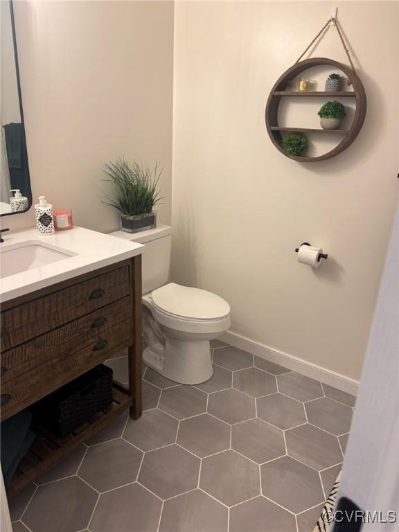 bathroom with tile patterned flooring, vanity, and toilet