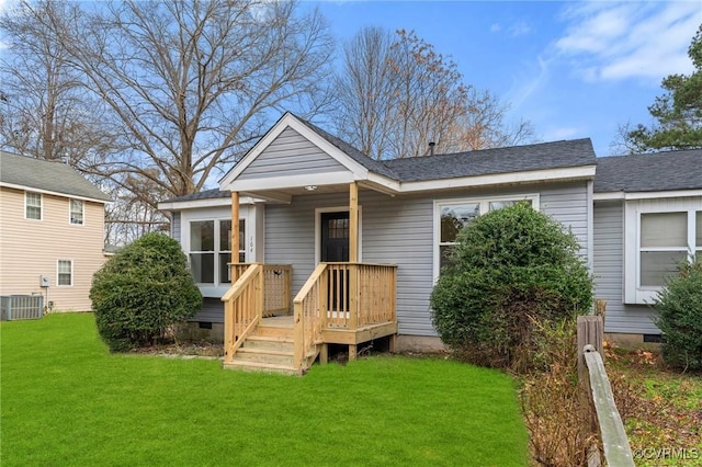 rear view of house with central AC unit and a lawn