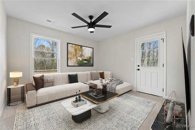 carpeted living room with ceiling fan and plenty of natural light