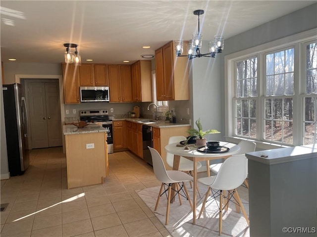 kitchen featuring sink, light tile patterned floors, hanging light fixtures, stainless steel appliances, and a center island