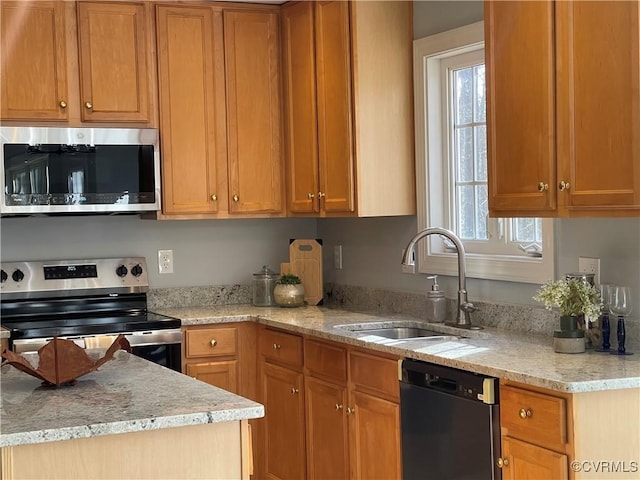 kitchen with appliances with stainless steel finishes, sink, and light stone counters