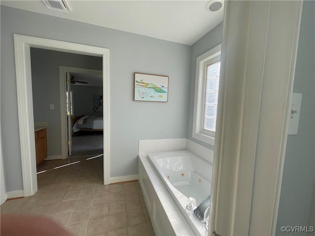 bathroom featuring vanity, tile patterned flooring, and tiled tub