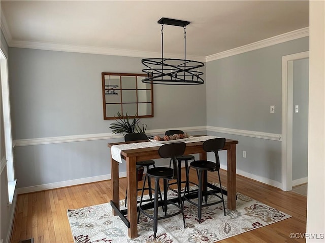 dining space featuring hardwood / wood-style flooring and crown molding