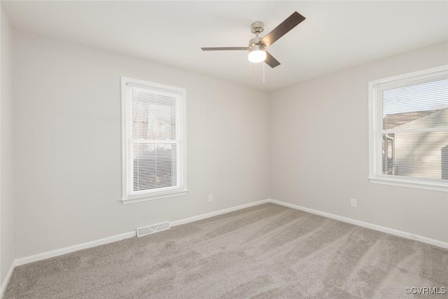 carpeted spare room featuring ceiling fan