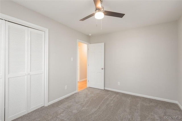 unfurnished bedroom featuring light colored carpet, ceiling fan, and a closet