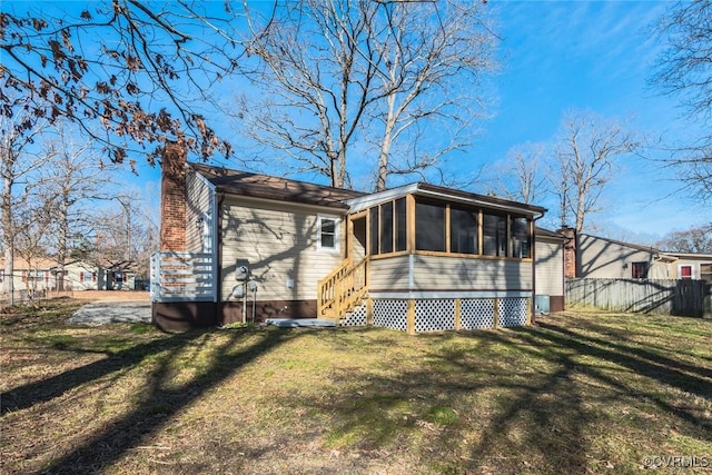 back of house with a yard and a sunroom