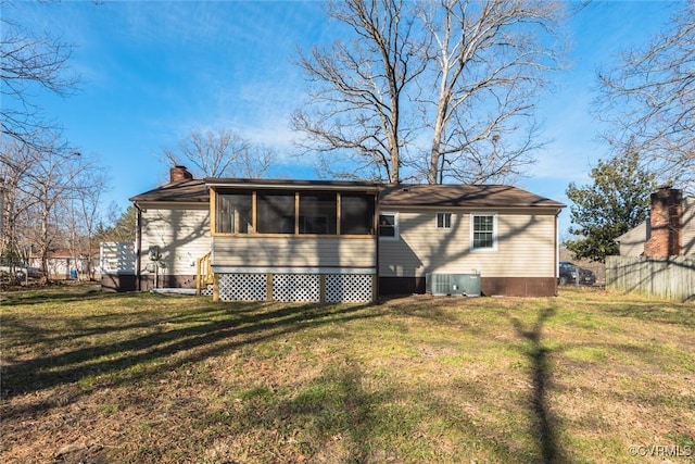 back of property with a lawn, a sunroom, and central air condition unit