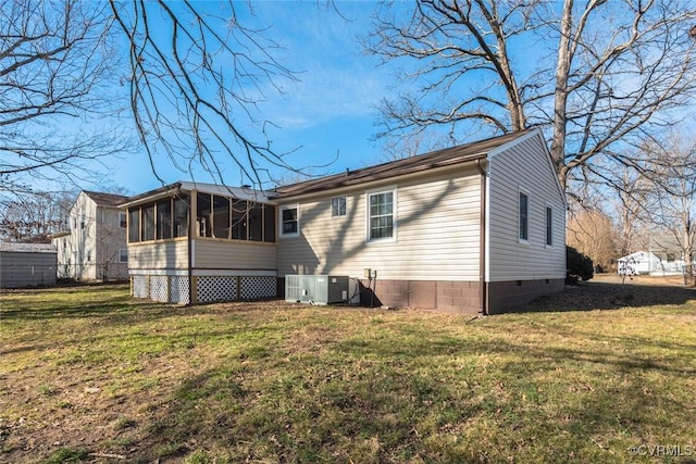 back of house featuring a sunroom, central air condition unit, and a lawn