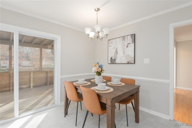 dining area featuring ornamental molding and an inviting chandelier