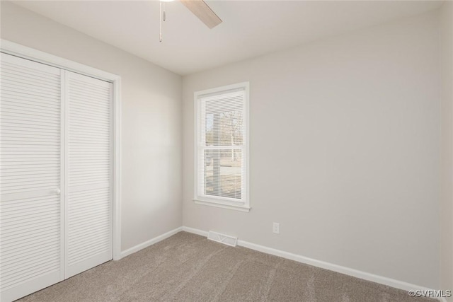 unfurnished bedroom with light colored carpet, a closet, and ceiling fan