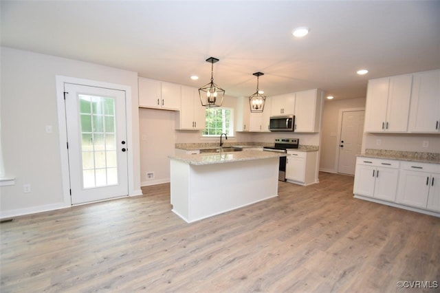 kitchen featuring appliances with stainless steel finishes, hanging light fixtures, a center island, light stone countertops, and white cabinets