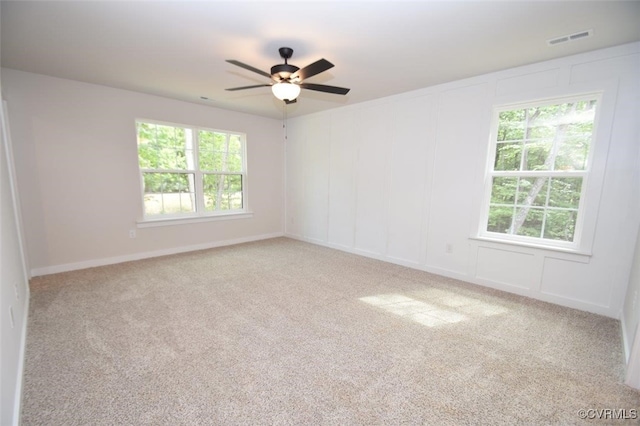 spare room with light colored carpet and ceiling fan