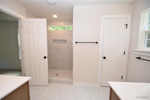 full bathroom featuring a walk in shower, a healthy amount of sunlight, marble finish floor, and vanity