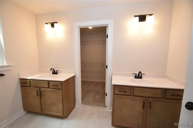 full bathroom featuring a sink, marble finish floor, and two vanities