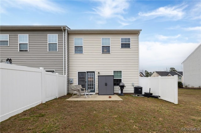 back of property with a fenced backyard, central AC, a lawn, and a patio