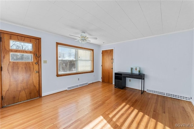 interior space with baseboard heating, ceiling fan, ornamental molding, and light wood-type flooring