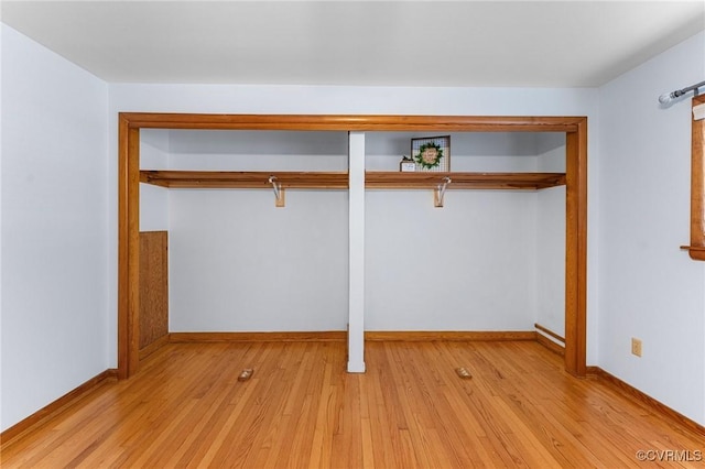 unfurnished bedroom featuring light hardwood / wood-style floors and a closet