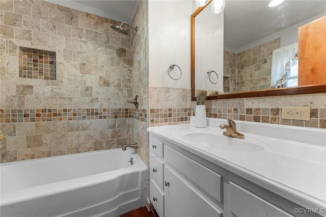 bathroom with tile walls, vanity, and tiled shower / bath combo