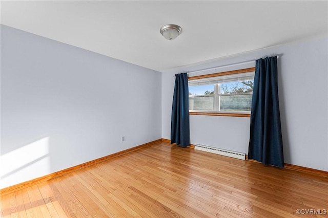 spare room featuring hardwood / wood-style flooring and a baseboard radiator