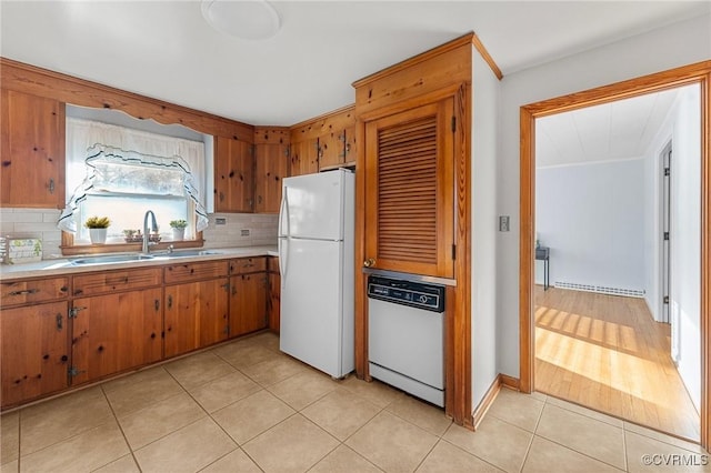 kitchen with white appliances, light tile patterned floors, sink, and backsplash