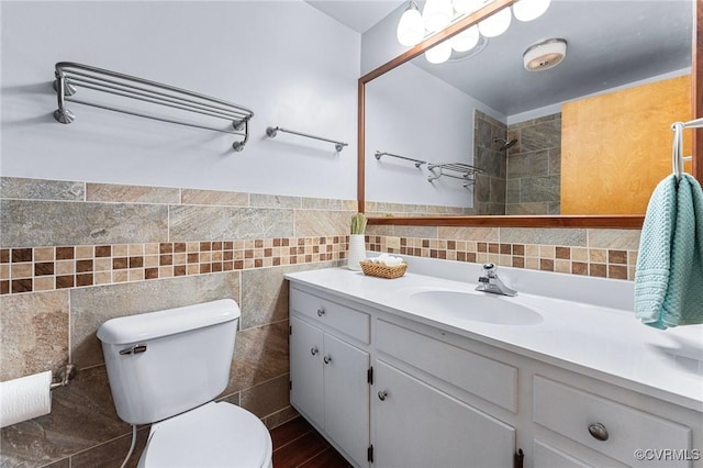 bathroom with vanity, tile walls, and toilet