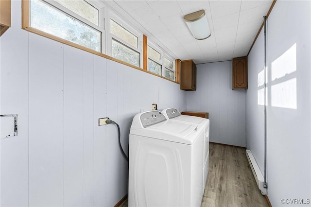 laundry area with cabinets, light hardwood / wood-style floors, and washer and dryer