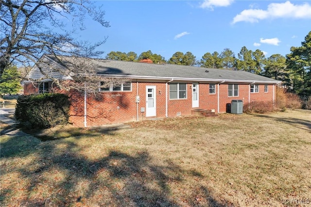 rear view of property featuring a yard and central air condition unit