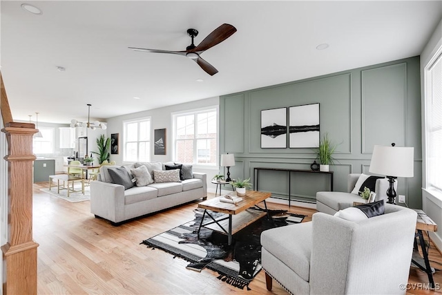 living room with ceiling fan and light hardwood / wood-style flooring