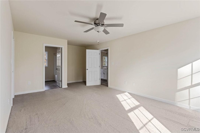 unfurnished bedroom with ensuite bath, ceiling fan, and carpet flooring