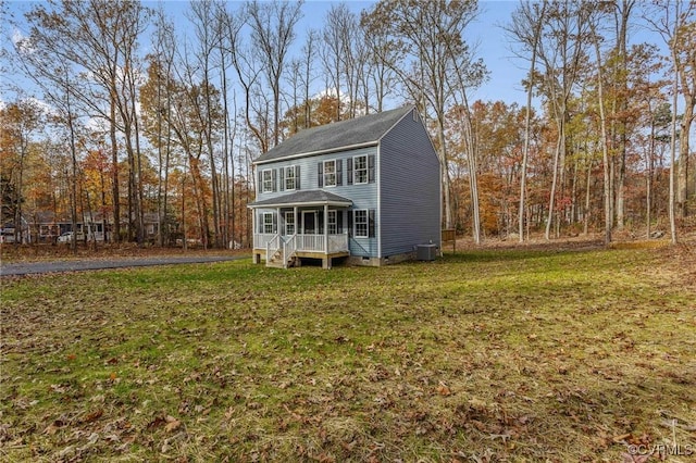 view of front of property featuring cooling unit, a front yard, and a porch