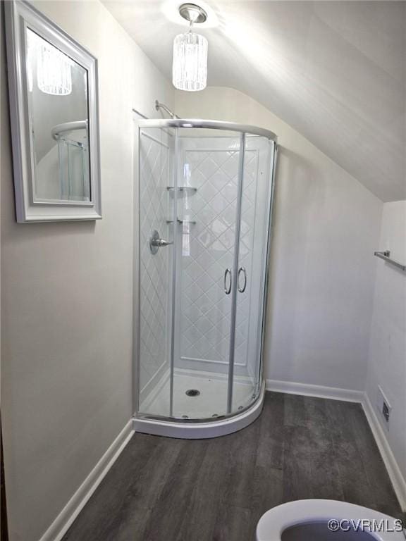 bathroom with wood-type flooring, an enclosed shower, and vaulted ceiling