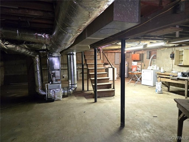 basement featuring water heater, washer / dryer, and electric panel