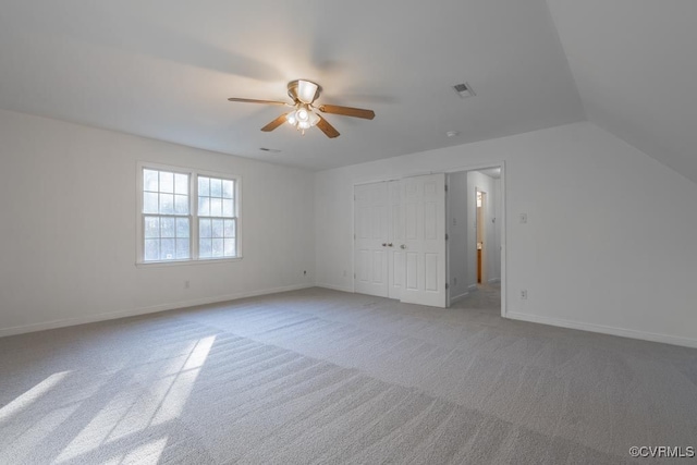 interior space with vaulted ceiling, ceiling fan, and carpet flooring