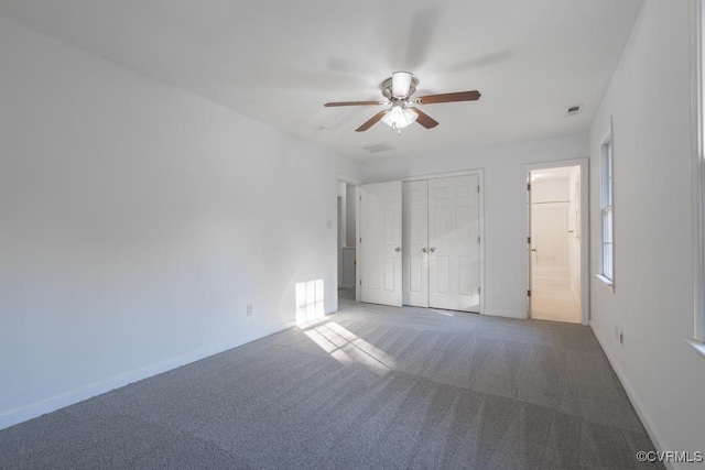 unfurnished bedroom featuring carpet floors, connected bathroom, ceiling fan, and a closet