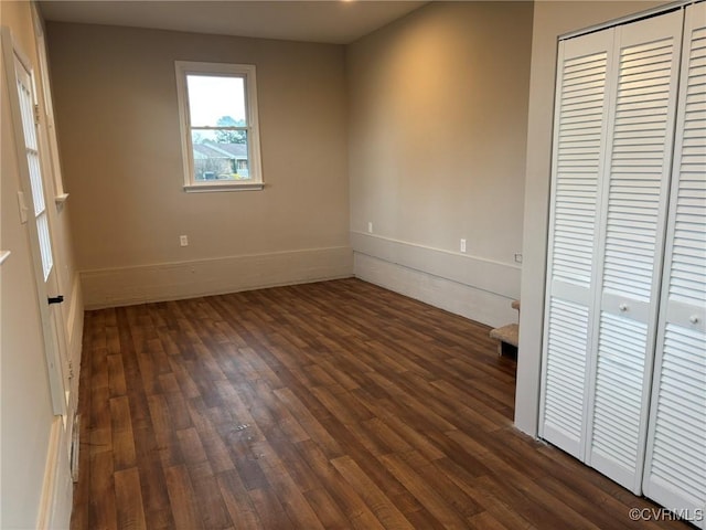 unfurnished bedroom with dark hardwood / wood-style flooring and a closet