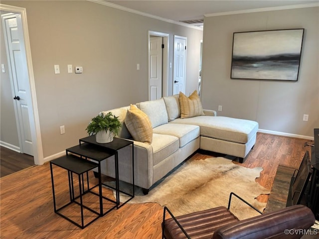 living room with wood-type flooring and ornamental molding