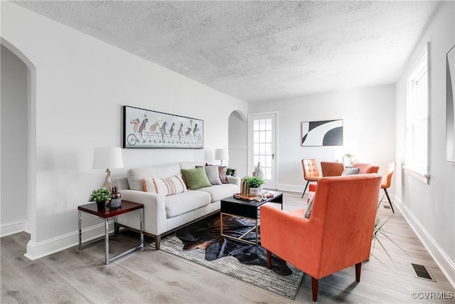 living room featuring light hardwood / wood-style floors and a textured ceiling